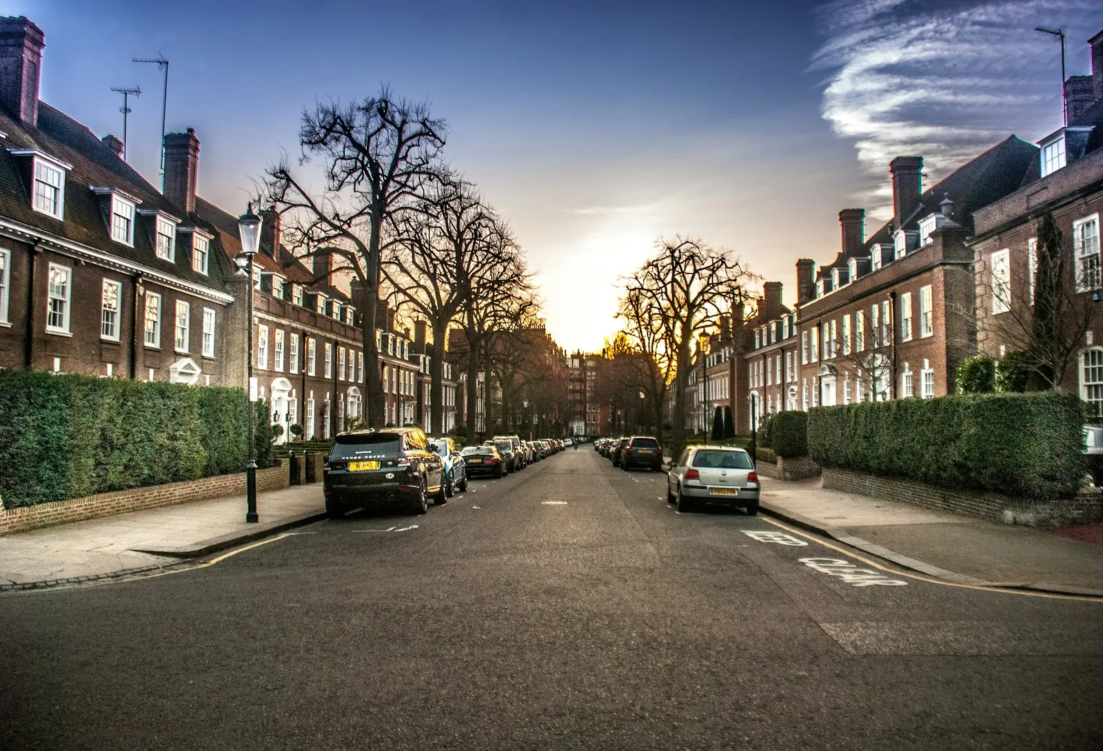 A residential street of brick terraced homes in Kensington at sunset.